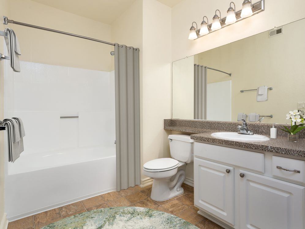 Classic Package I bath with faux granite countertop, white shaker cabinetry, and hard surface flooring