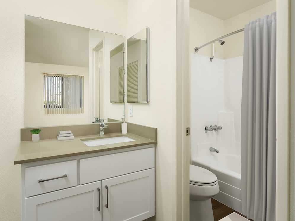 Renovated I bath with grey quartz countertops, white cabinetry, and hard surface flooring