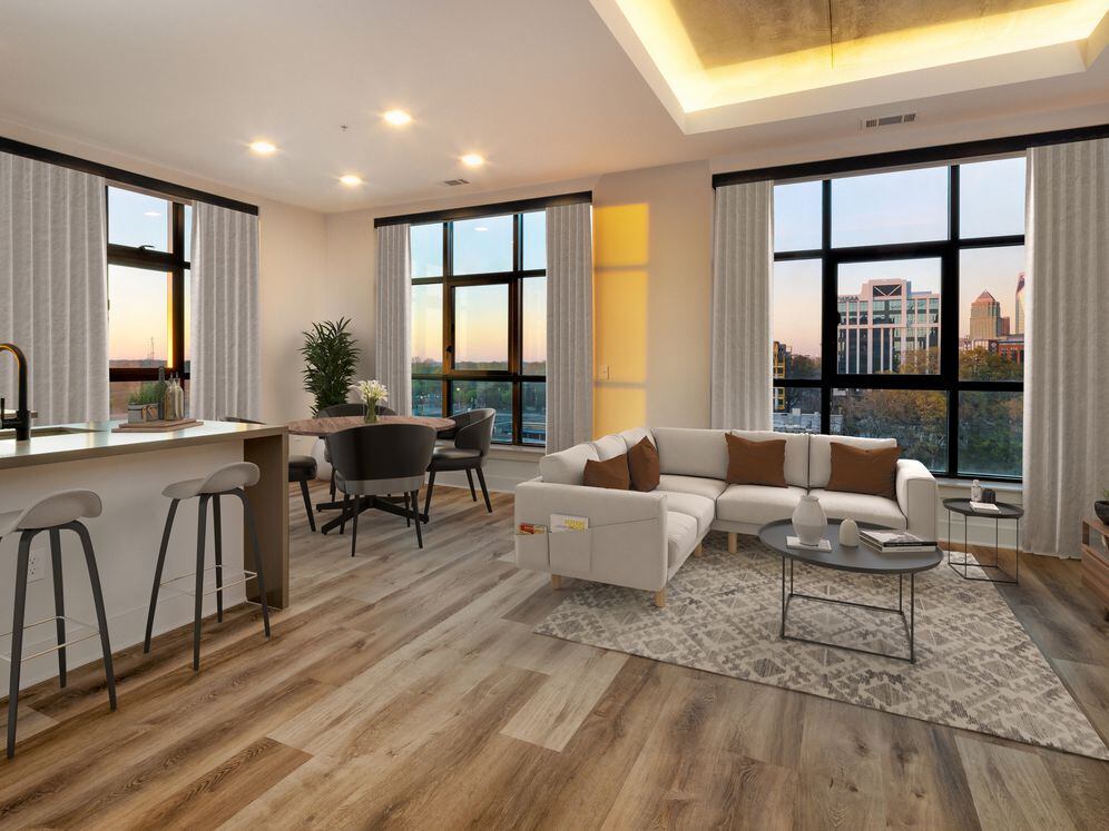 Kitchen, living, and dining areas with hard surface flooring throughout and floor-to-ceiling windows