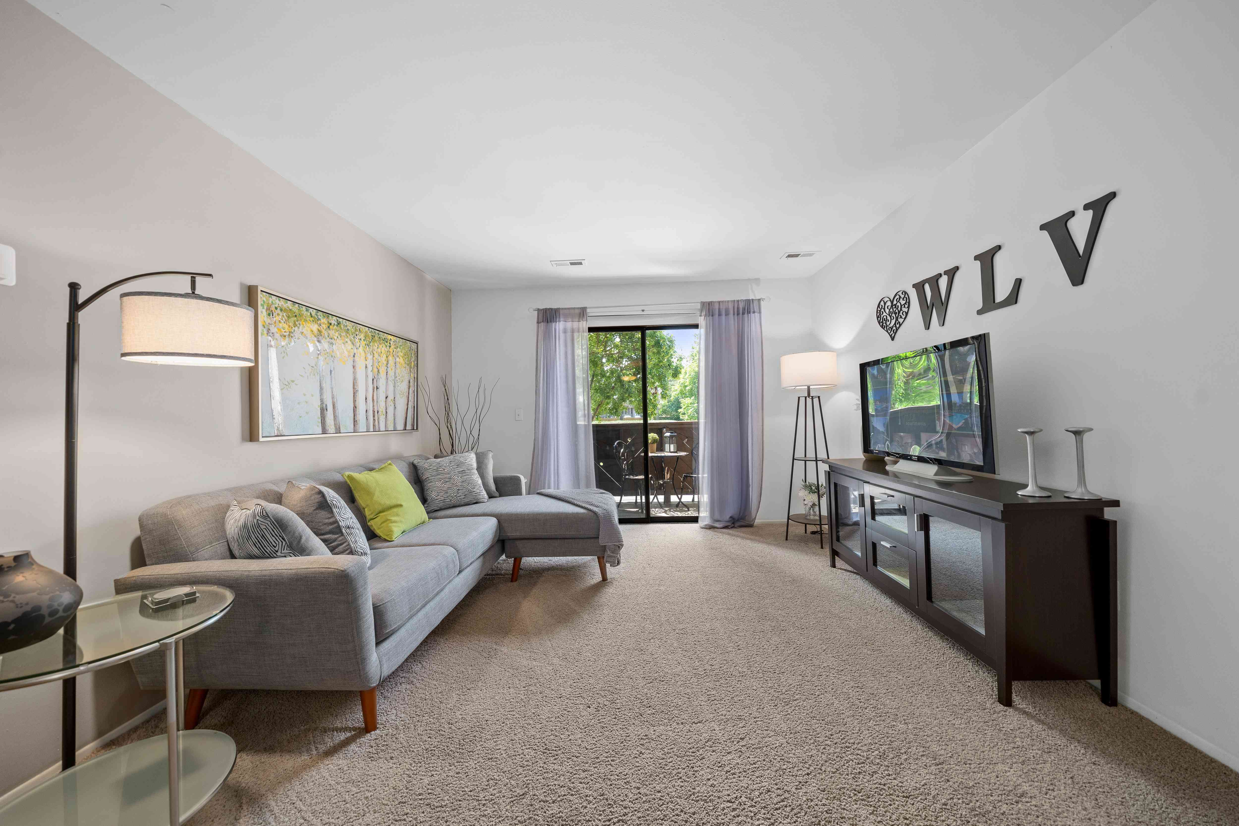 Cozy living room with natural light at Woodland Villa Apartments in Westland, MI.
