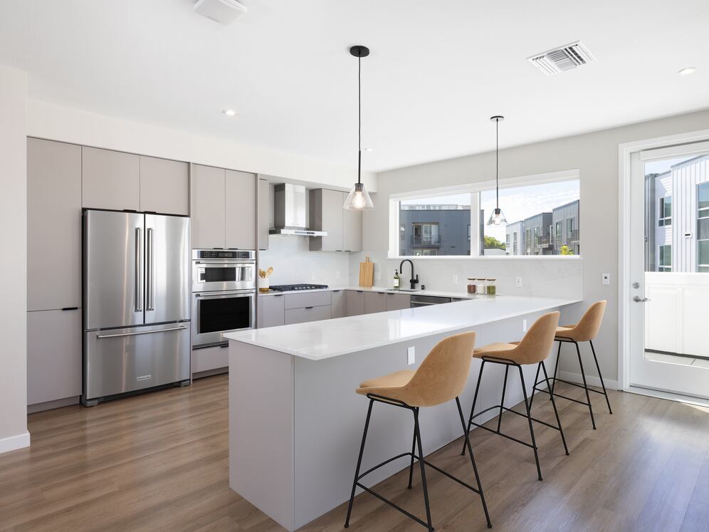 Signature Collection I 4-Bedroom Townhome Kitchen with light grey cabinetry, white marbled quartz countertop, and upgraded stainless steel appliances