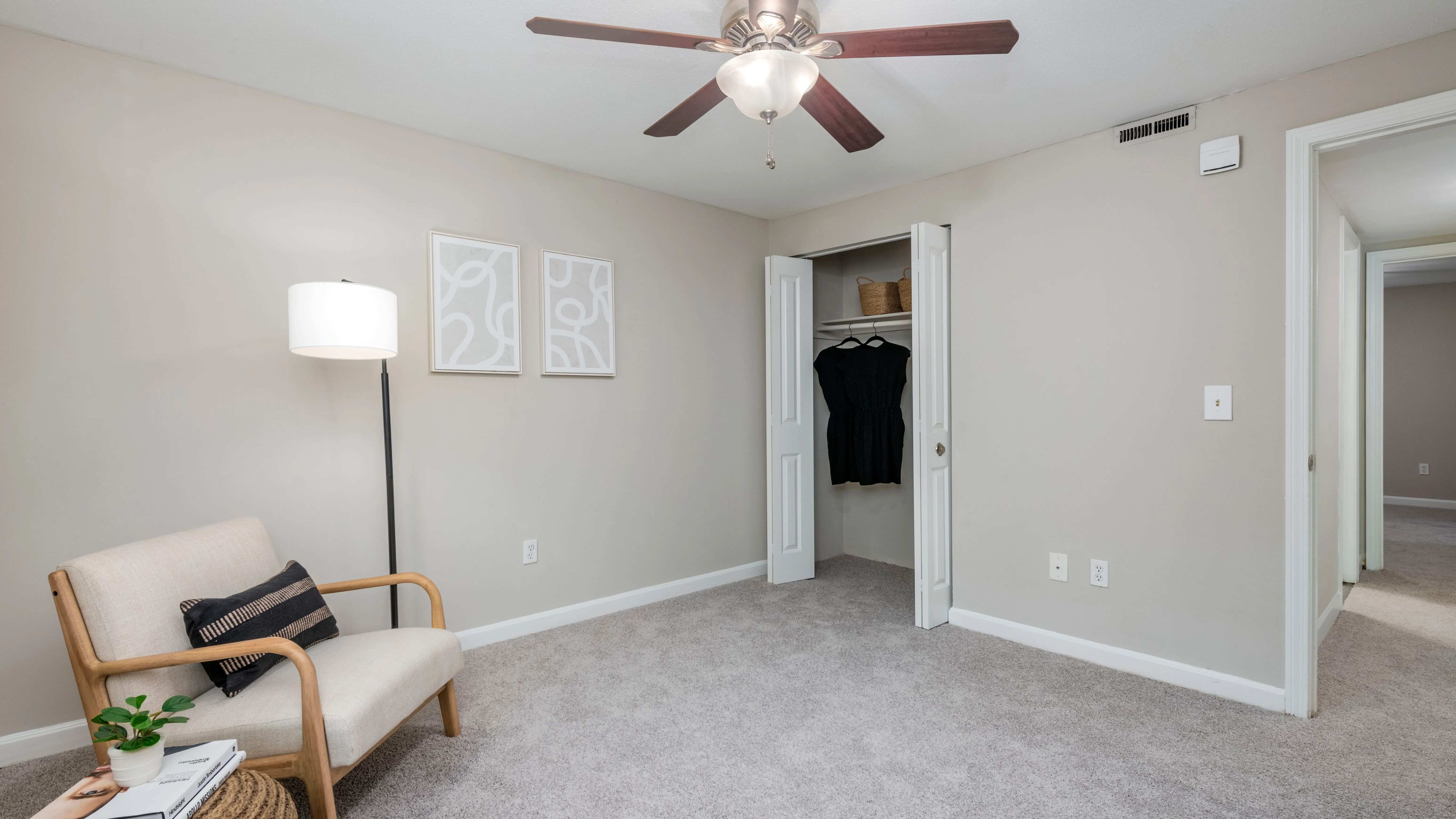 Your bedroom, a timeless space of elegance with plush carpeting, a ceiling fan, and a roomy closet.