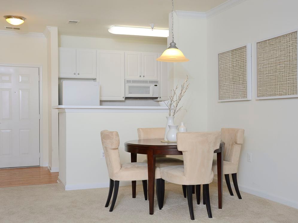 Classic I dining area with carpeted flooring and kitchen with white cabinetry, white appliances, and hard surface flooring