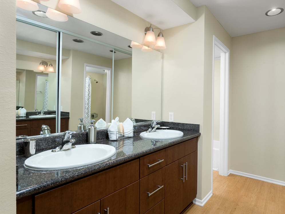 Classic Package I bath with chestnut cabinetry, grey speckled granite countertops, and hard surface flooring
