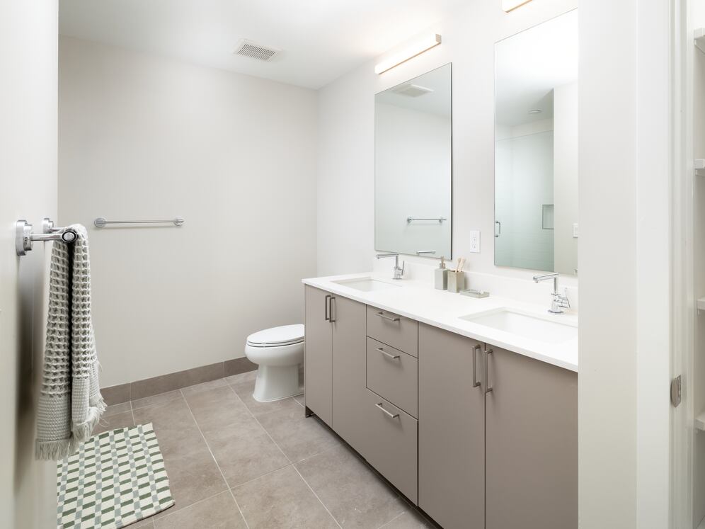 Upgrade Collection I primary bath with double-sink vanity, white quartz countertops, standing shower, and built in linen closet with shelving