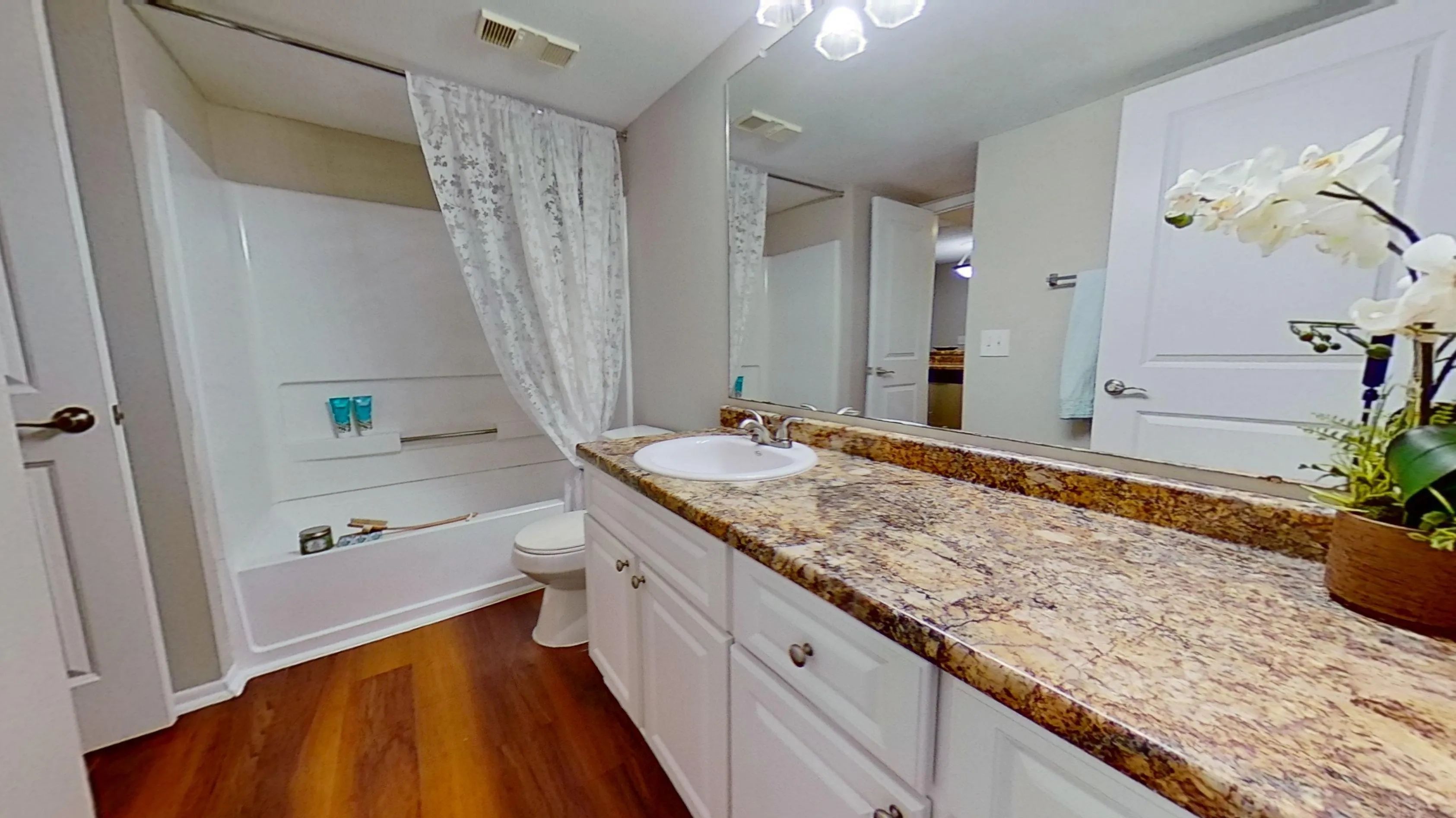 Enjoy the comfort of a beautifully designed bathroom in The Newport Autograph floor plan featuring elegant granite countertops, ample storage space, and a full-size tub for ultimate relaxation.
