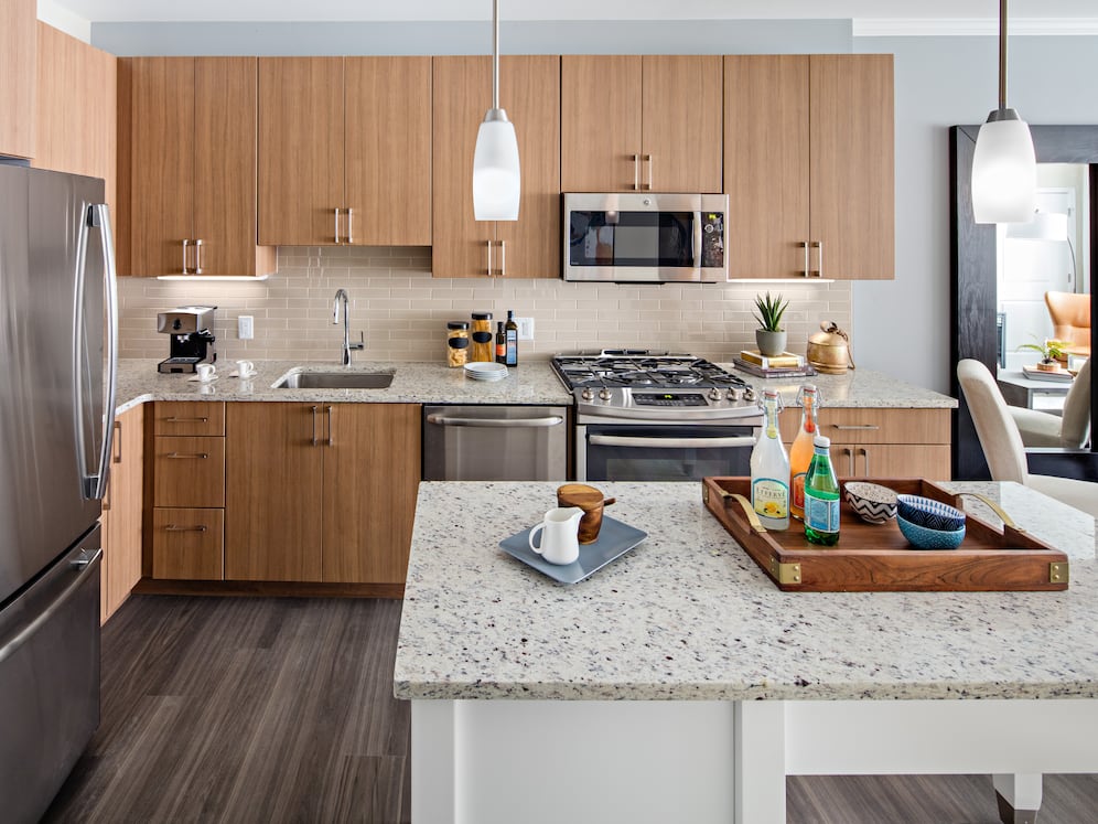 Traditional Collection Kitchen with oak cabinetry, beige tile backsplash, grey granite countertops, stainless steel appliances, and hard surface flooring