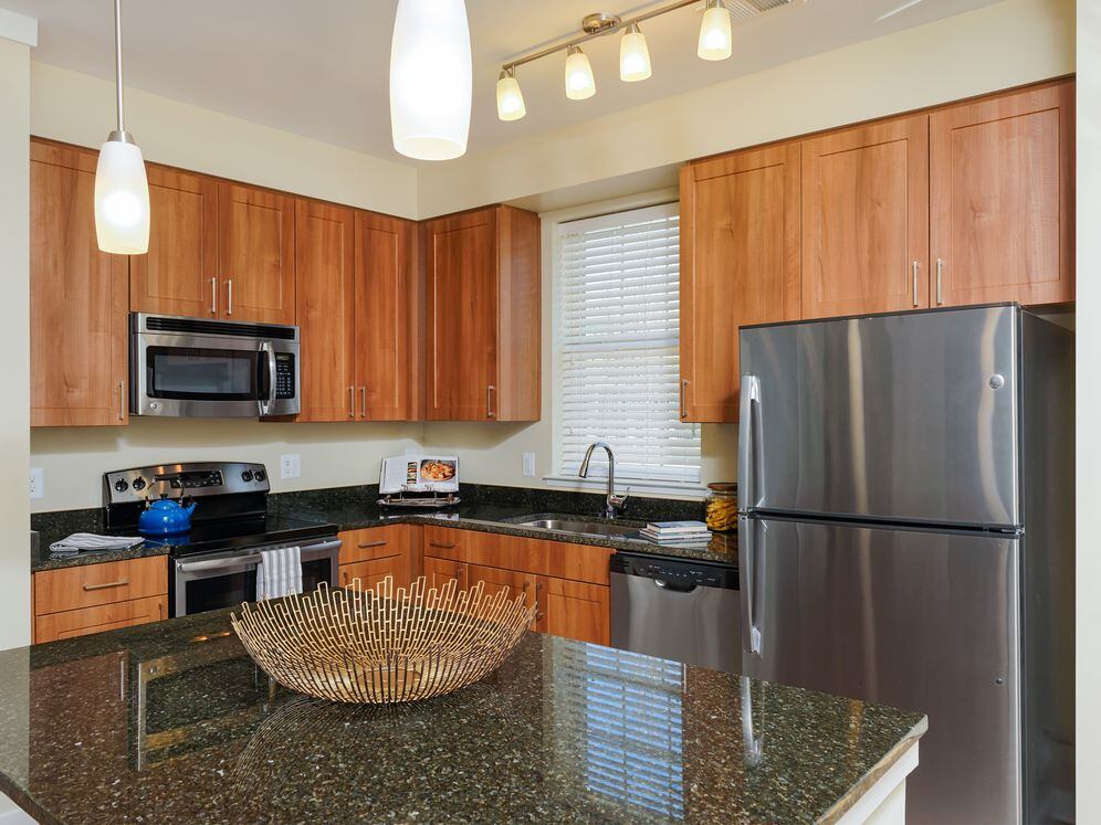 Open concept kitchen with granite countertops, stainless-steel appliances, kitchen island and hard surface flooring
