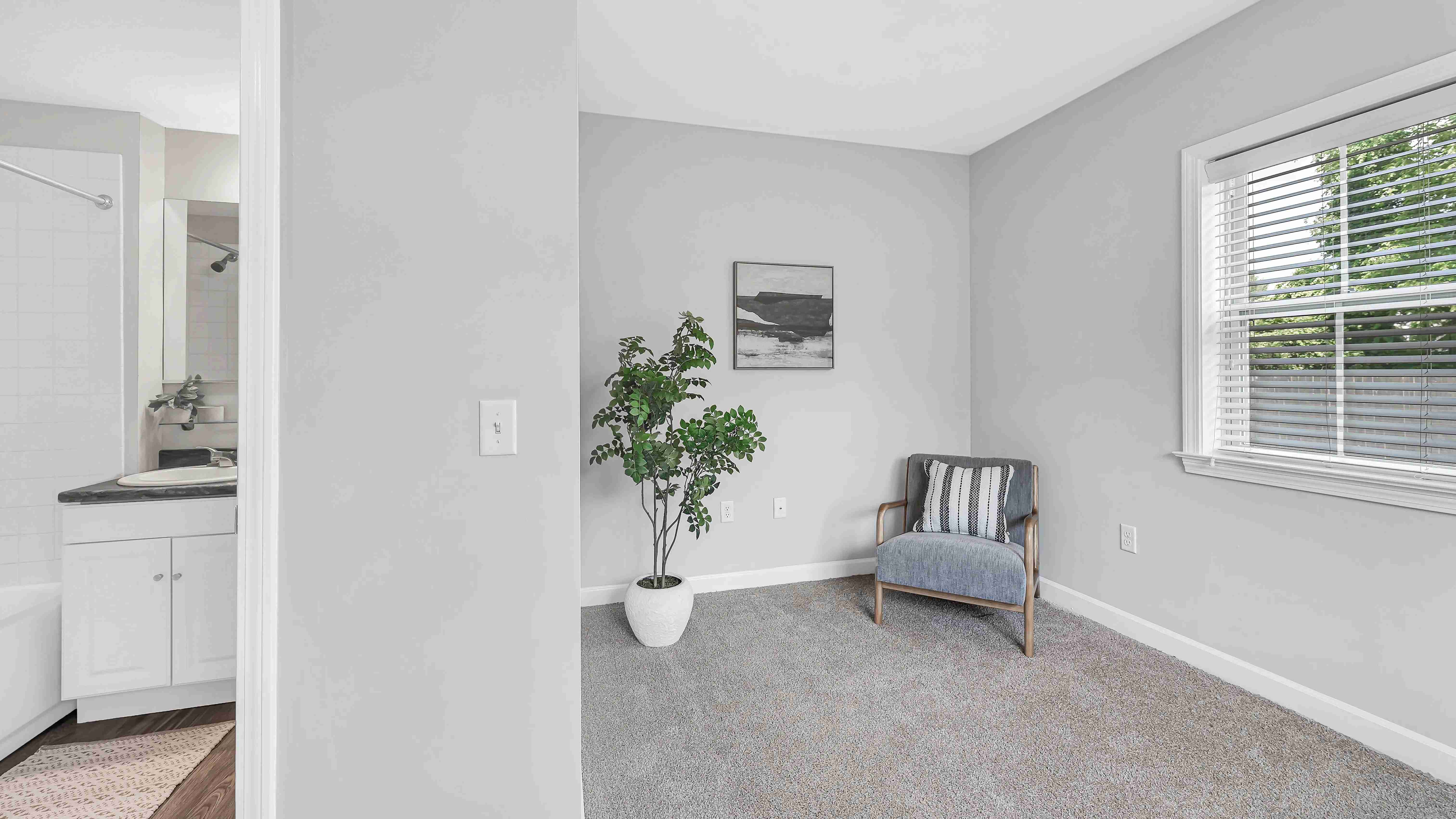 The ultimate college space - a cozy bedroom with plush carpet, large window, and ensuite bathroom access for ultimate convenience.