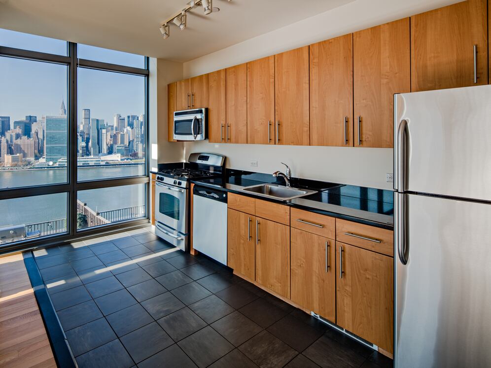 Classic Package III kitchen with stainless steel appliances, maple cabinetry, black granite countertops, and tile flooring