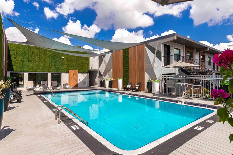 Bask in the Florida sunshine on the expansive sundeck which is complemented by shaded areas, modern lounge chairs, and vibrant landscaping, offering the ultimate relaxation spot for residents.