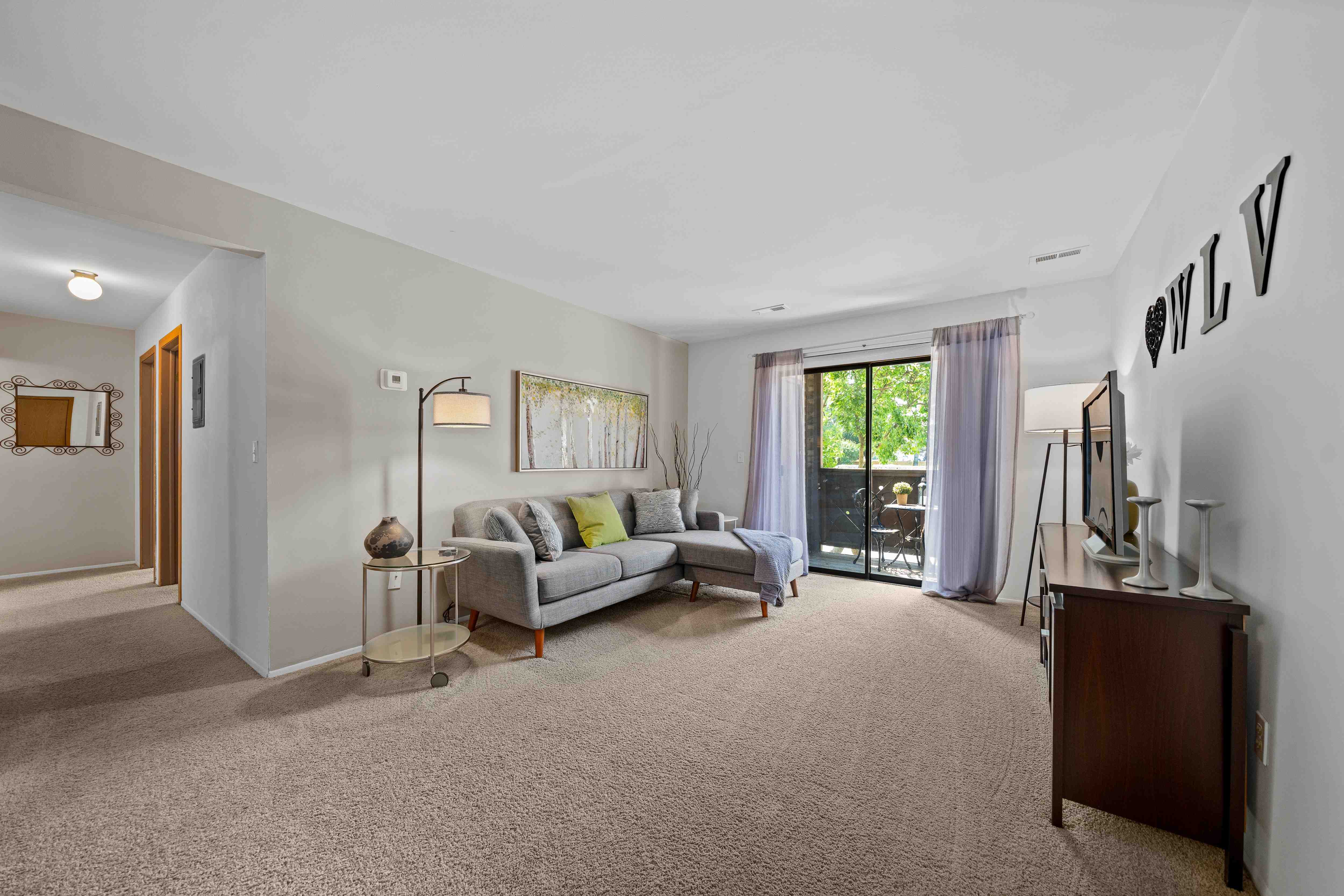 Cozy living room with natural light at Woodland Villa Apartments in Westland, MI.