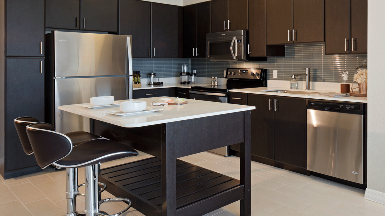Modern kitchens with stainless steel appliances, tile backsplashes and moveable islands.