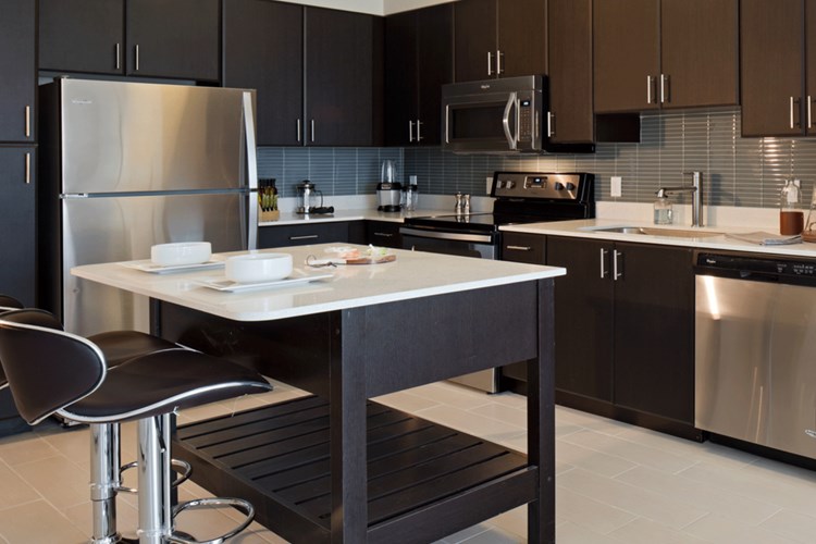Modern kitchens with stainless steel appliances, tile backsplashes and moveable islands.