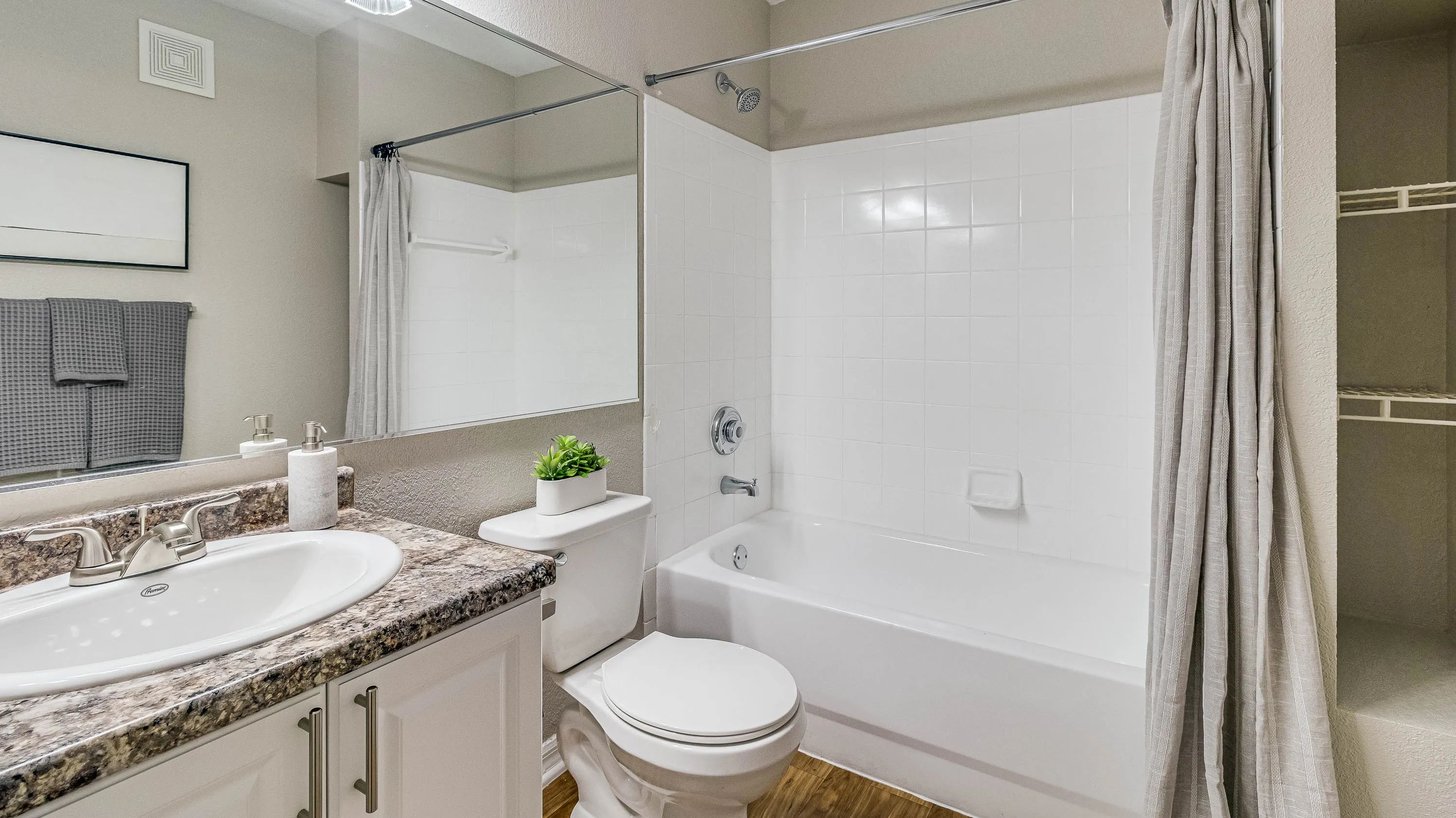 Bathrooms feature granite-style counters, wood-style flooring, and a tub/shower combination.