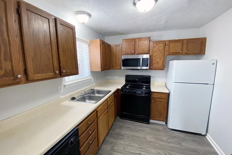 Fully applianced kitchens featuring ample cabinetry.