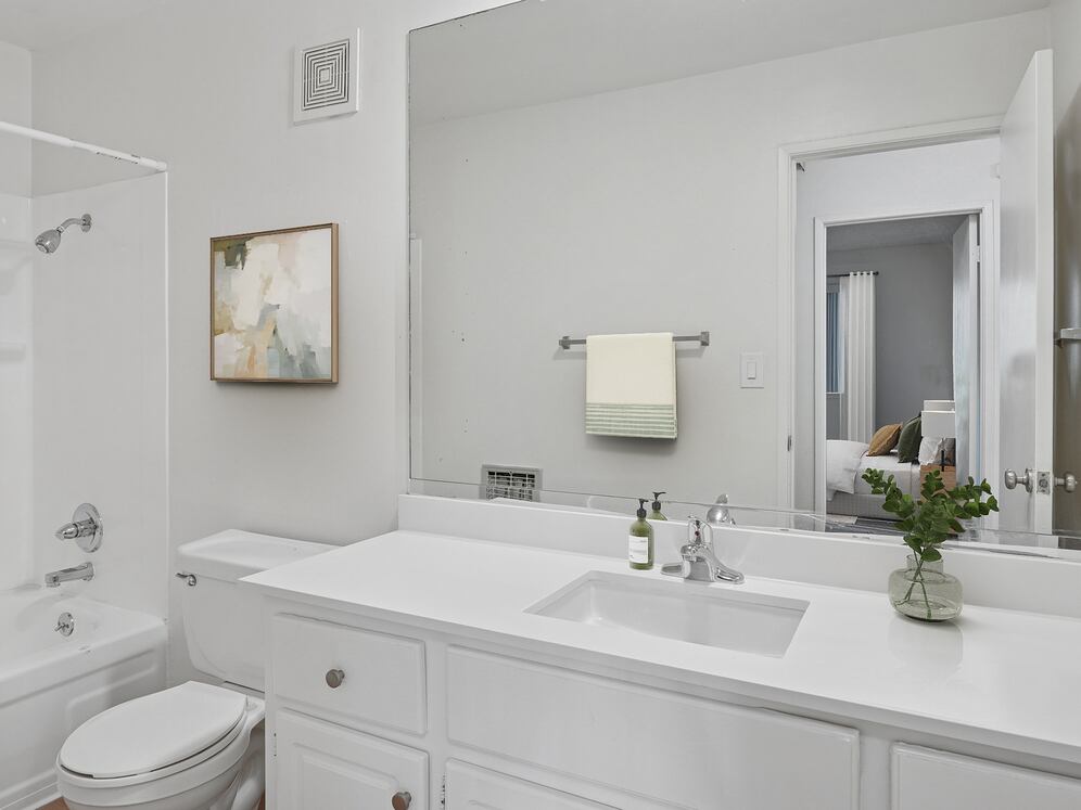 Renovated Package I bath with white quartz countertop, white cabinetry, and hard surface flooring