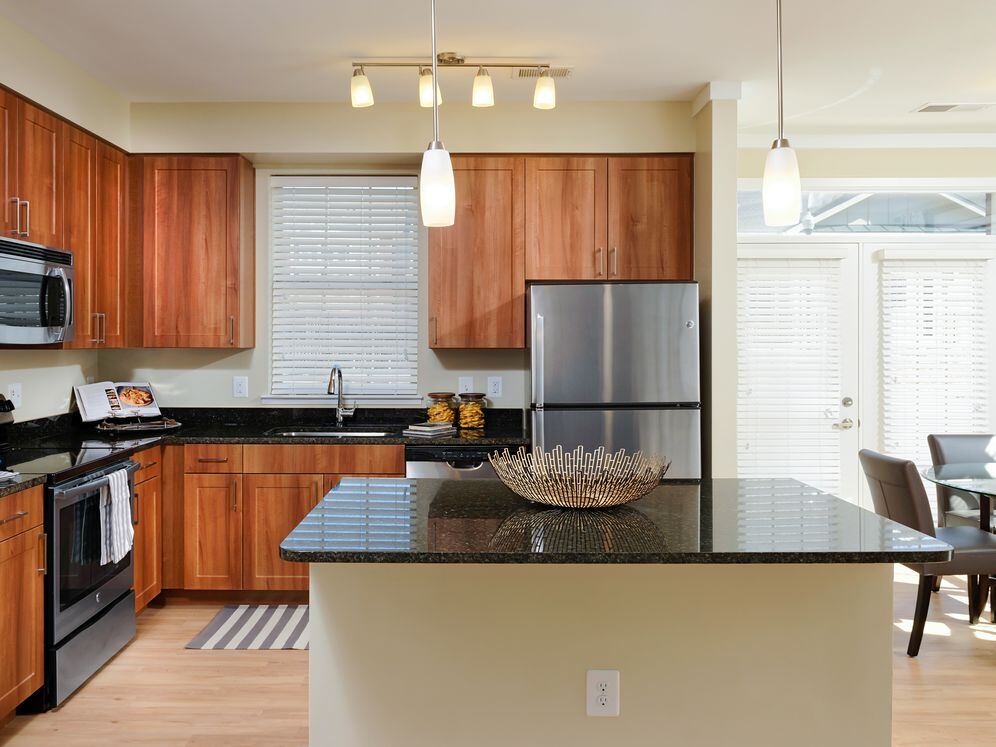 Open concept kitchen with granite countertops, stainless-steel appliances, kitchen island and hard surface flooring