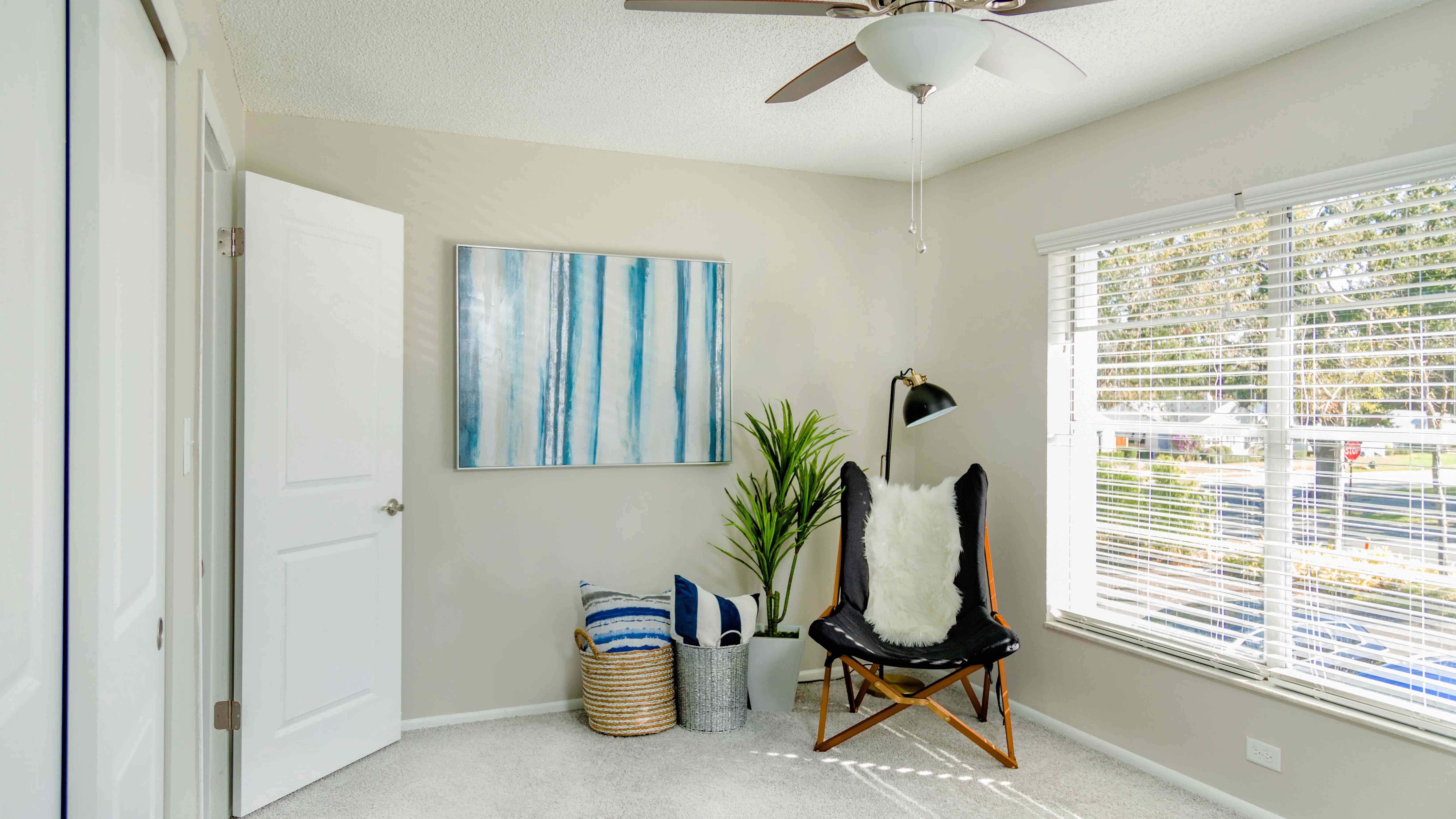 Revel in the warmth of a sun-drenched bedroom with plush carpeting, a roomy walk-in closet, and a modern ceiling fan for ultimate comfort – a space inviting you to unwind and recharge.