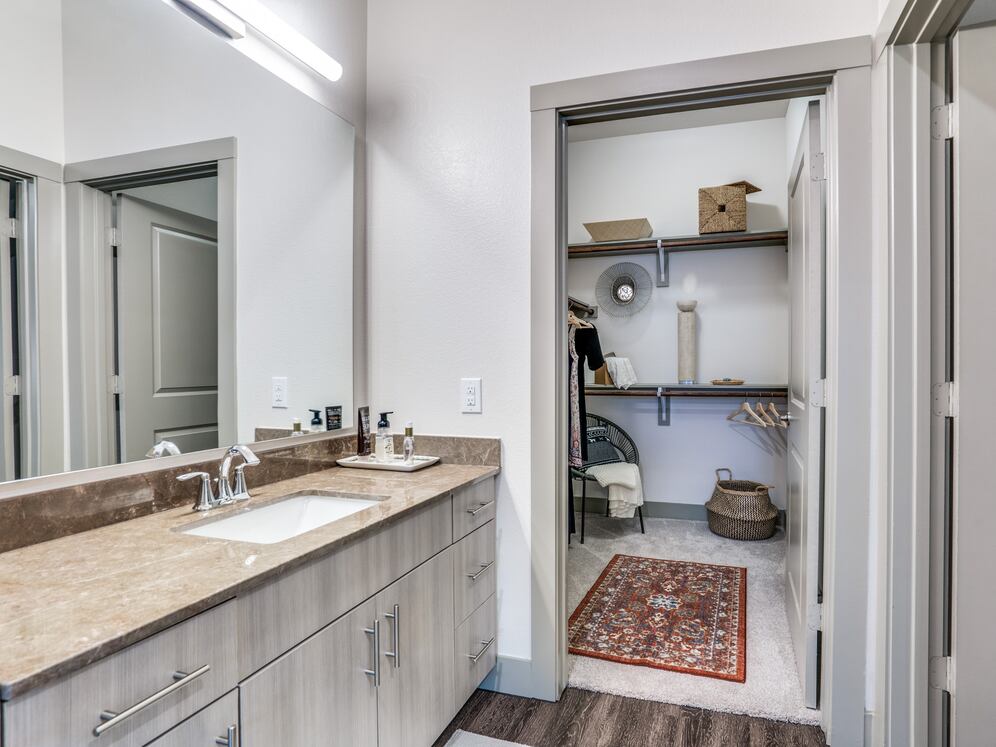 Gray finish package bath with brown granite countertop and hard surface flooring