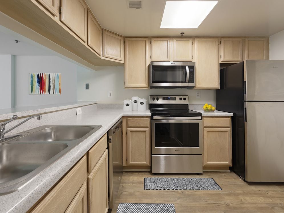 Classic Package I kitchen with grey countertops, oak cabinetry, stainless steel appliances, and hard surface flooring