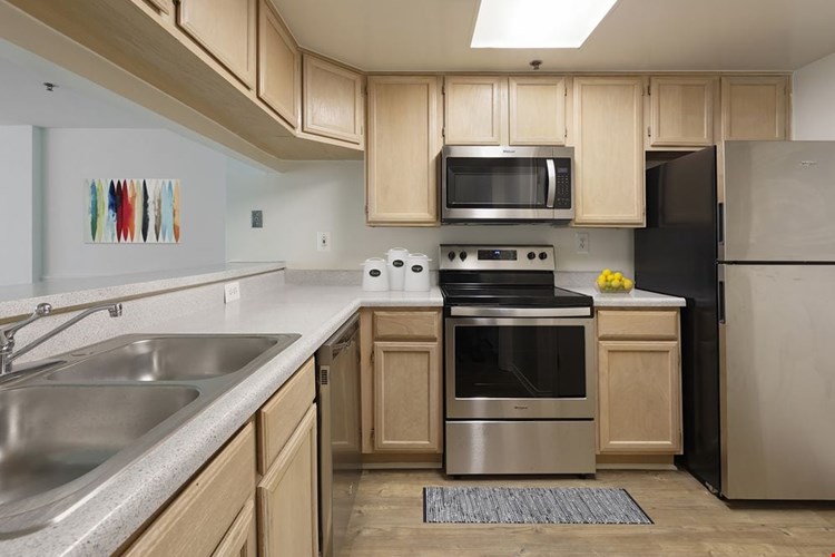 Classic Package I kitchen with grey countertops, oak cabinetry, stainless steel appliances, and hard surface flooring