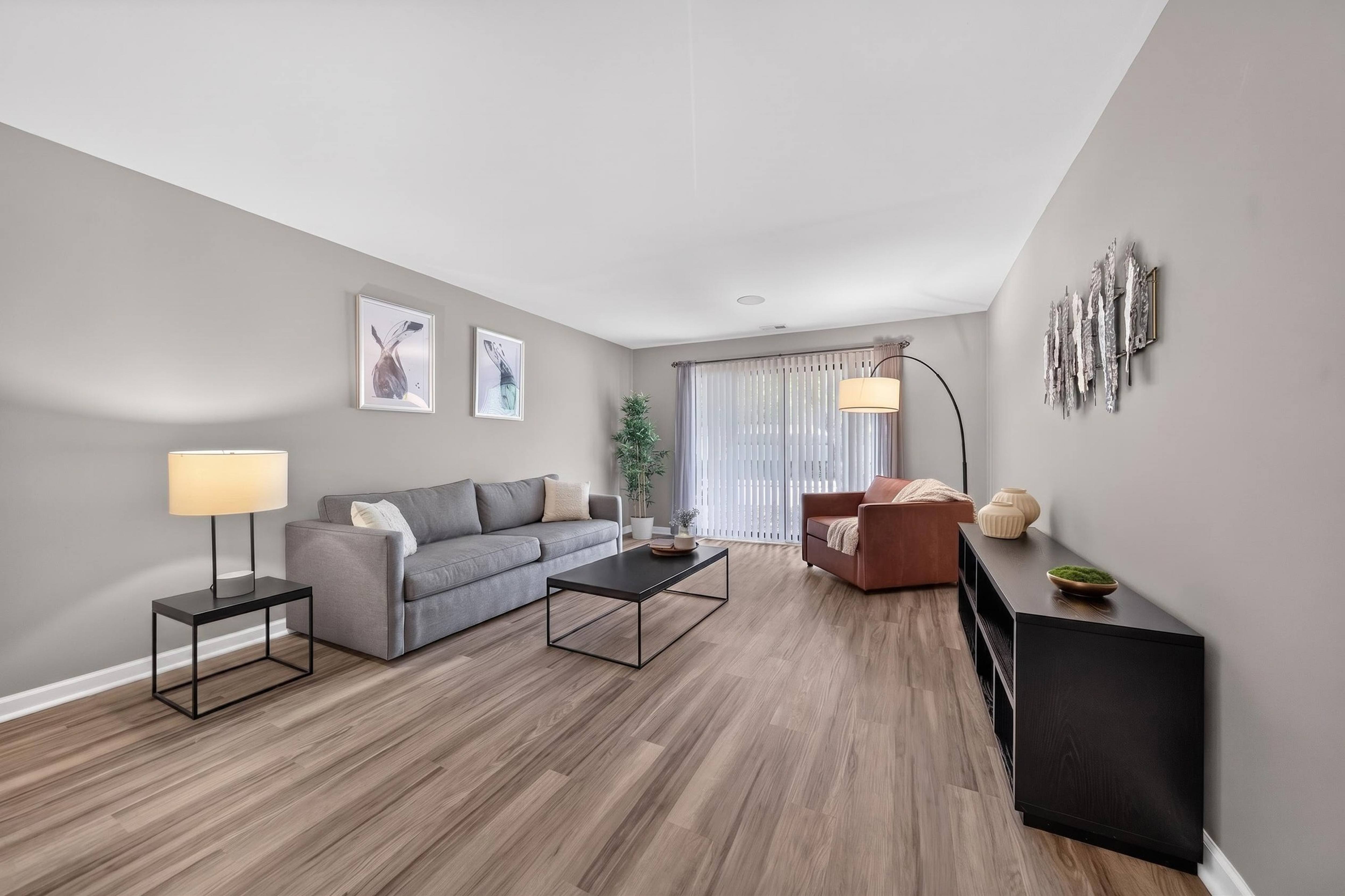 Spacious Living Room with Sliding Glass Door at Lakeside Village Apartments in Clinton Township, MI.