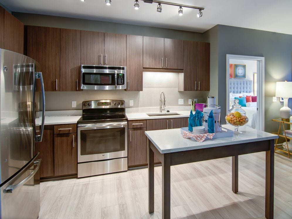 Open concept kitchen with quartz stone countertops, stainless-steel appliances, kitchen island and hard surface flooring