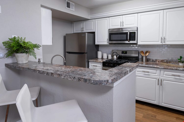 Whip up meals with ease in this stylish kitchen, complete with stainless steel appliances, white cabinetry, and a breakfast bar perfect for casual dining.