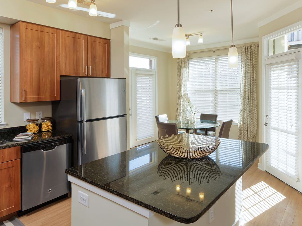 Open concept kitchen with granite countertops, stainless-steel appliances, kitchen island and hard surface flooring