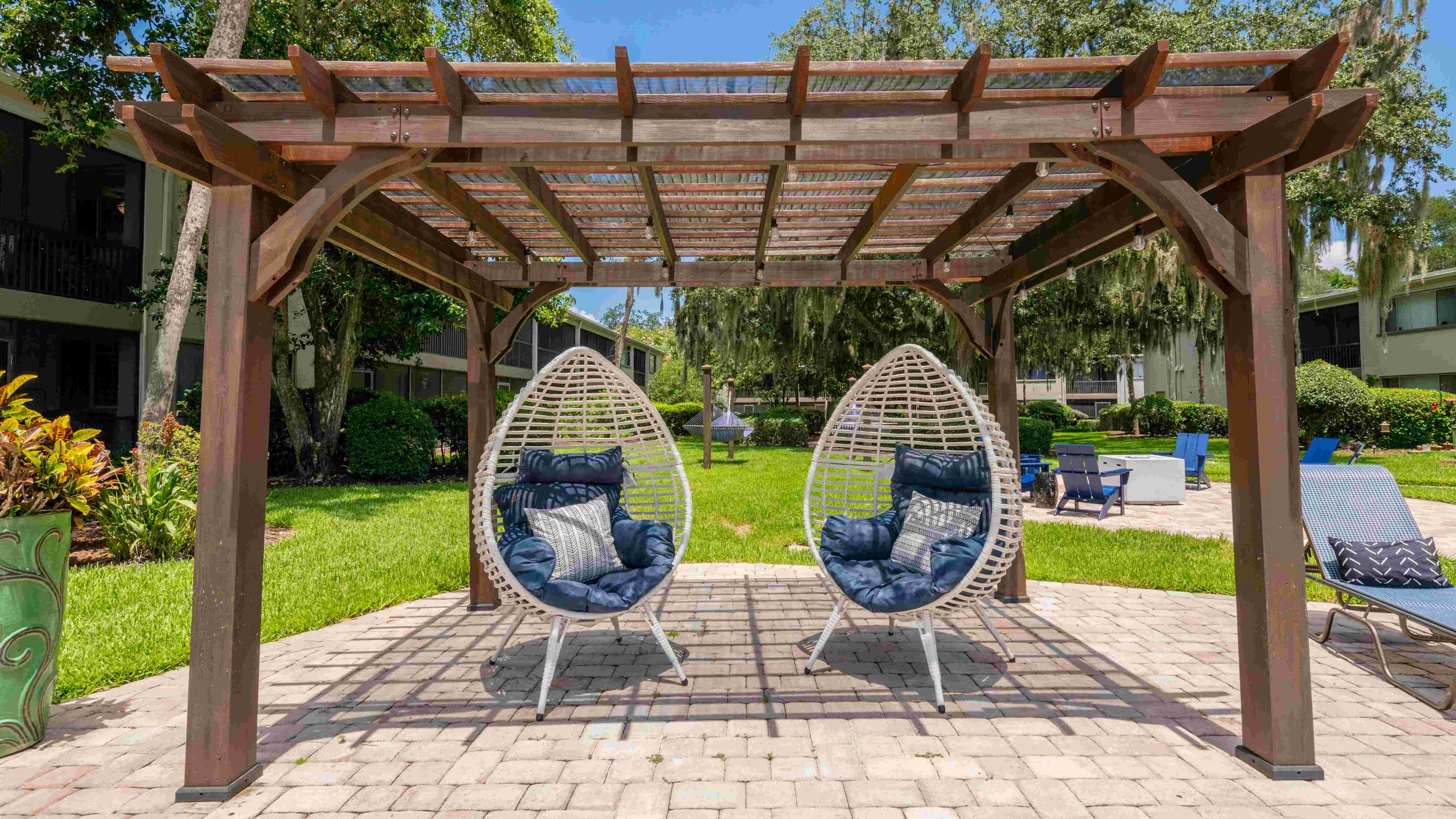 Immerse yourself in plush, modern seating beneath the pergola's tranquility.