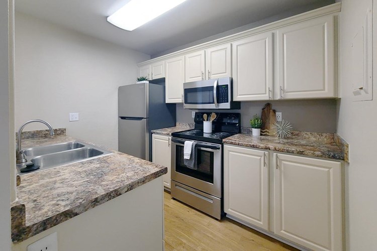 Our kitchen features granite-style countertops, wood-style flooring, and stainless steel appliances.