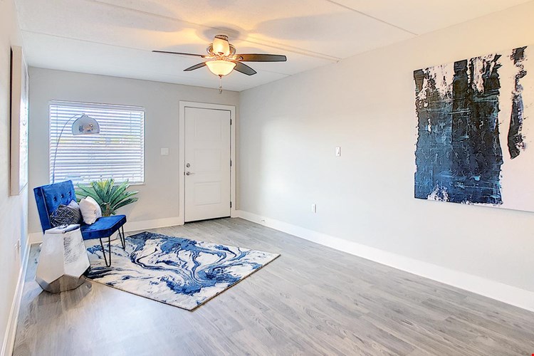 Spacious living rooms with wood-style flooring and a multi-speed ceiling fan.