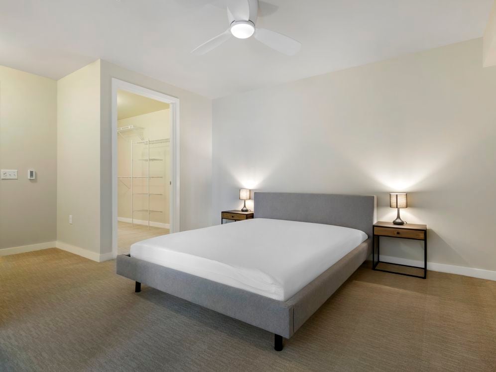 Furnished+ apartment homes feature queen bed with mattress, dresser, nightstands, and lamps (Representative Image – exact items and style of furnishings may vary)