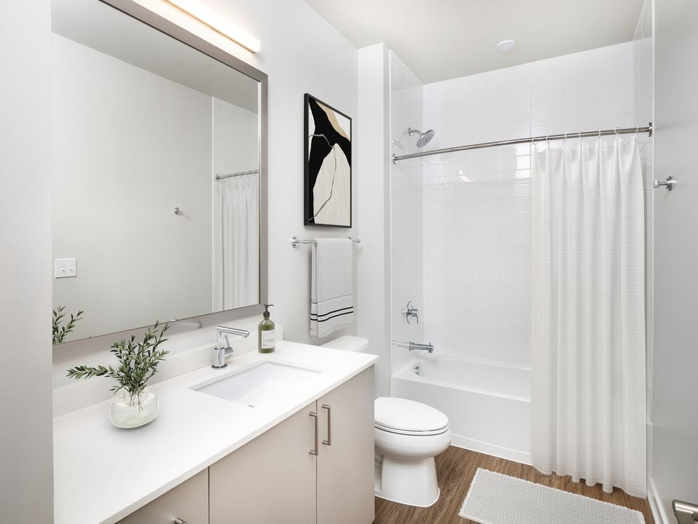 Design Collection II bath with cream quartz countertop, oak cabinetry, and hard surface flooring