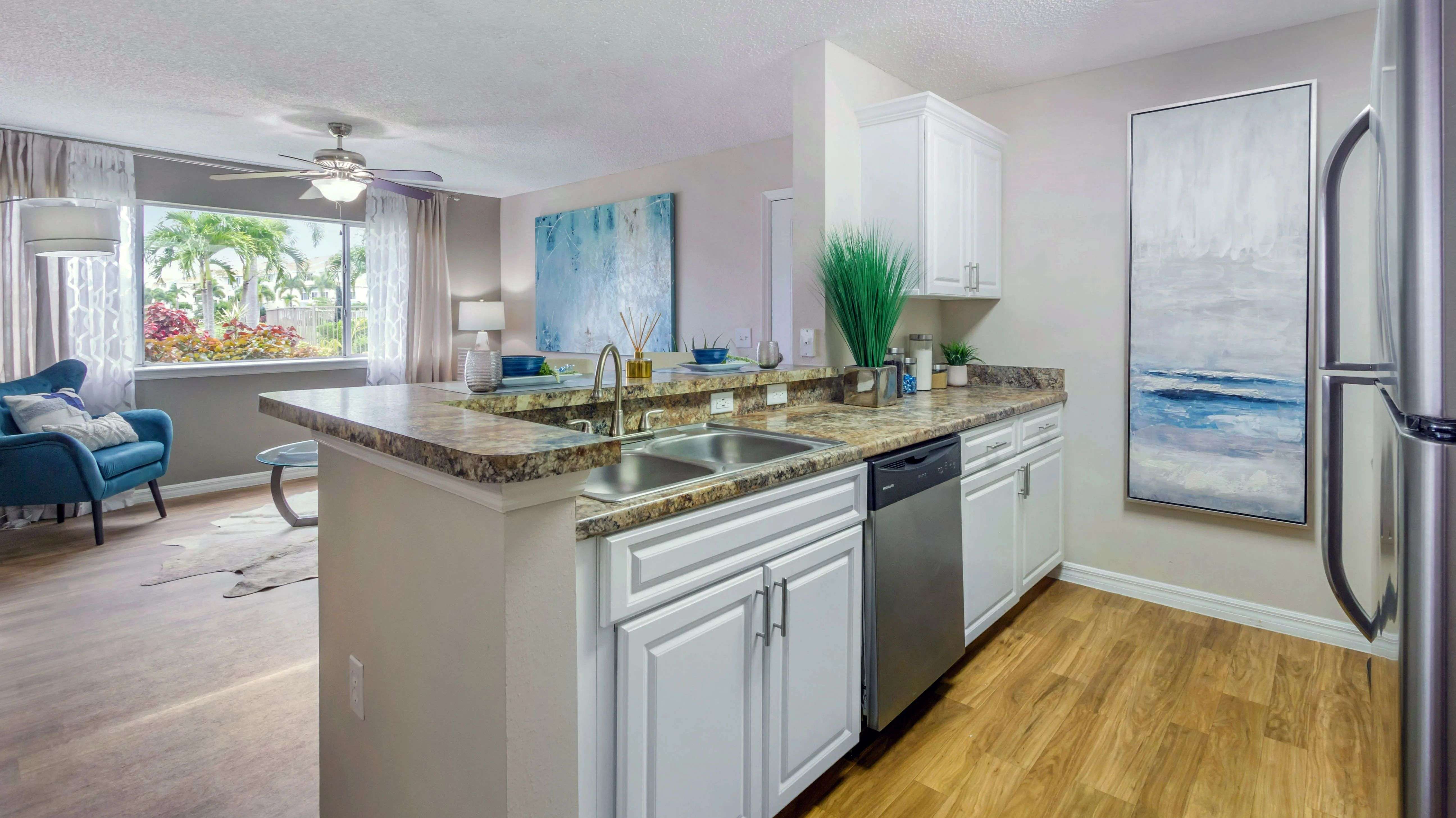 Discover the warmth and charm of Lexington Palms' golden Mascarella kitchen countertops paired with bright white cabinetry and contemporary stainless steel finishes.