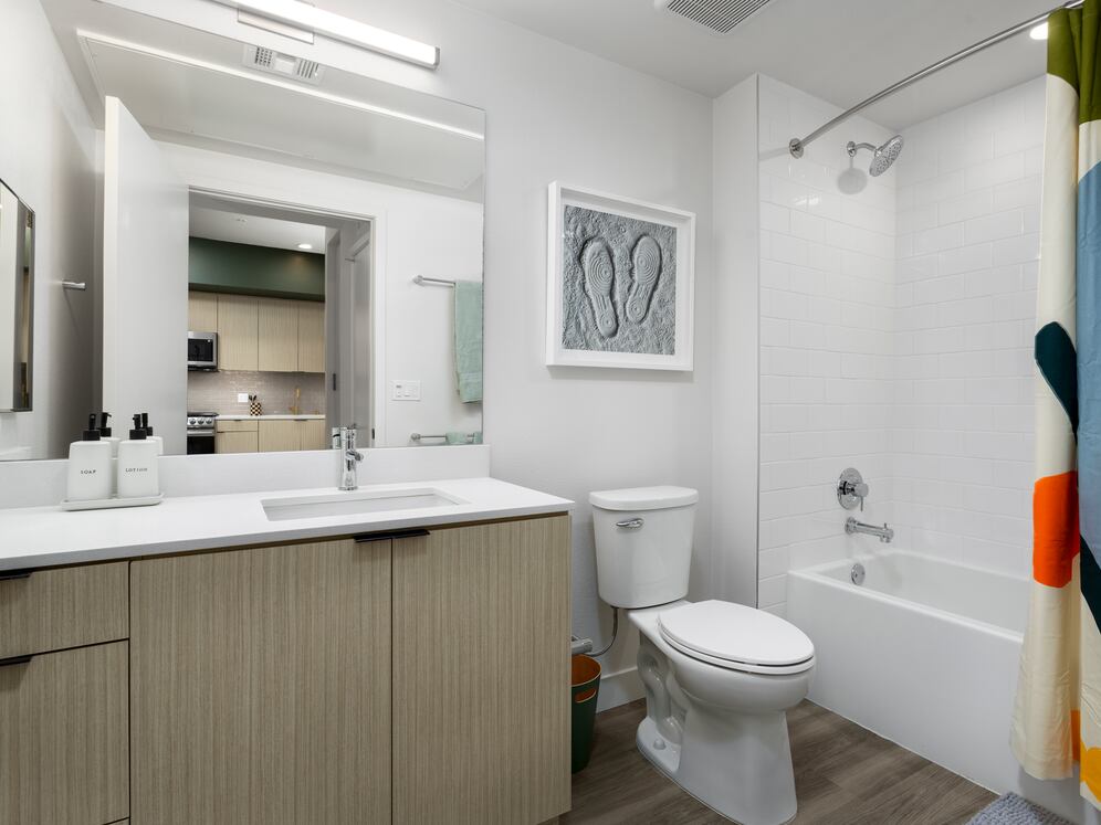 Finish Package I Bath with light oak cabinetry, white quartz countertop, and hard-surface flooring