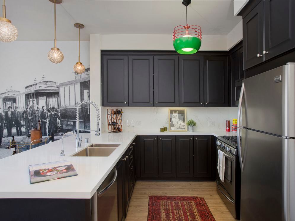 Kitchens with dark cabinetry, white quartz countertops, white tile backsplash, stainless steel appliances, and hard surface flooring