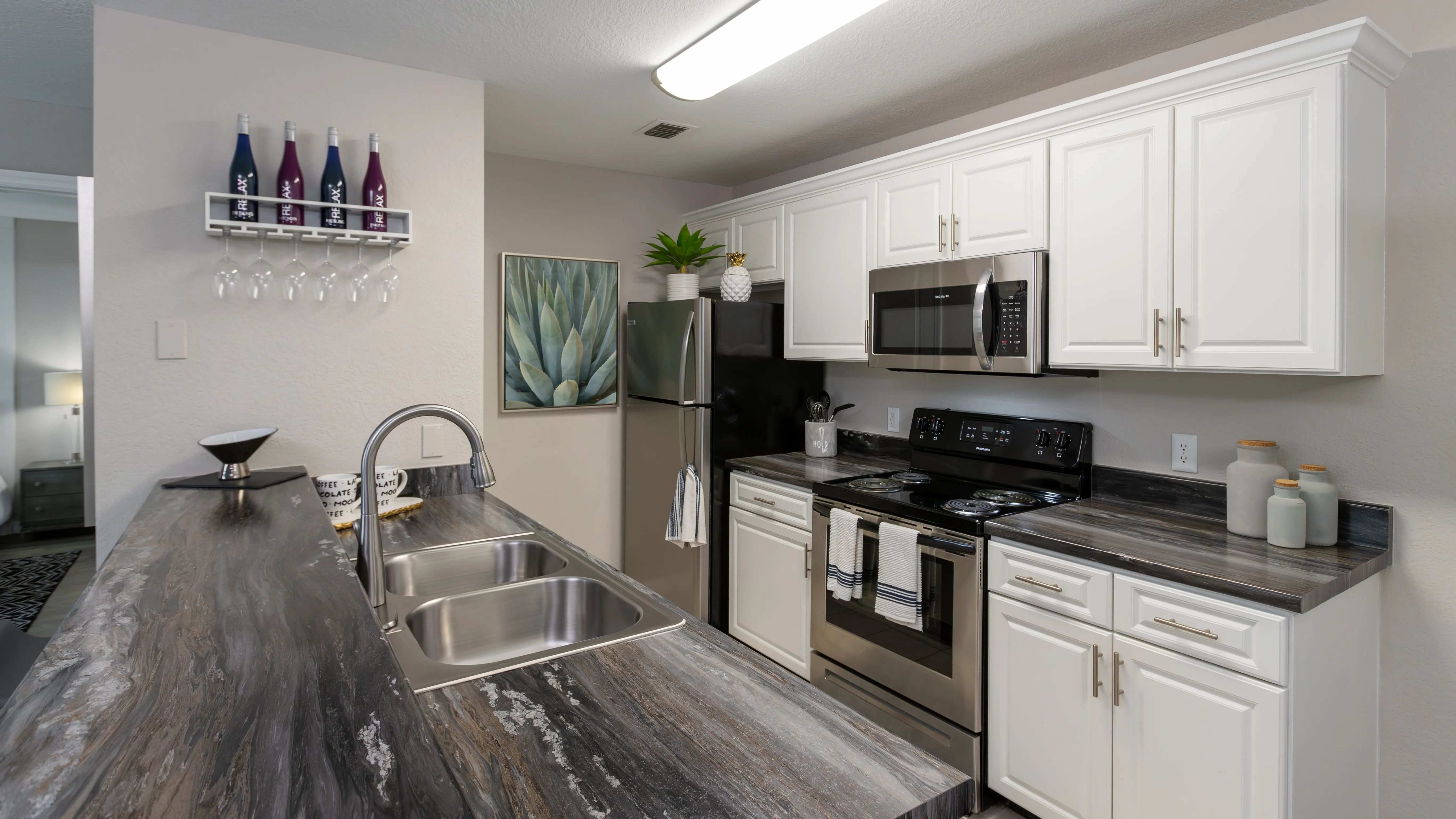 Experience a contemporary kitchen at Soleil Blu Apartments in St Cloud, FL, featuring stainless steel appliances, sleek countertops, custom cabinetry, and stylish finishes.
