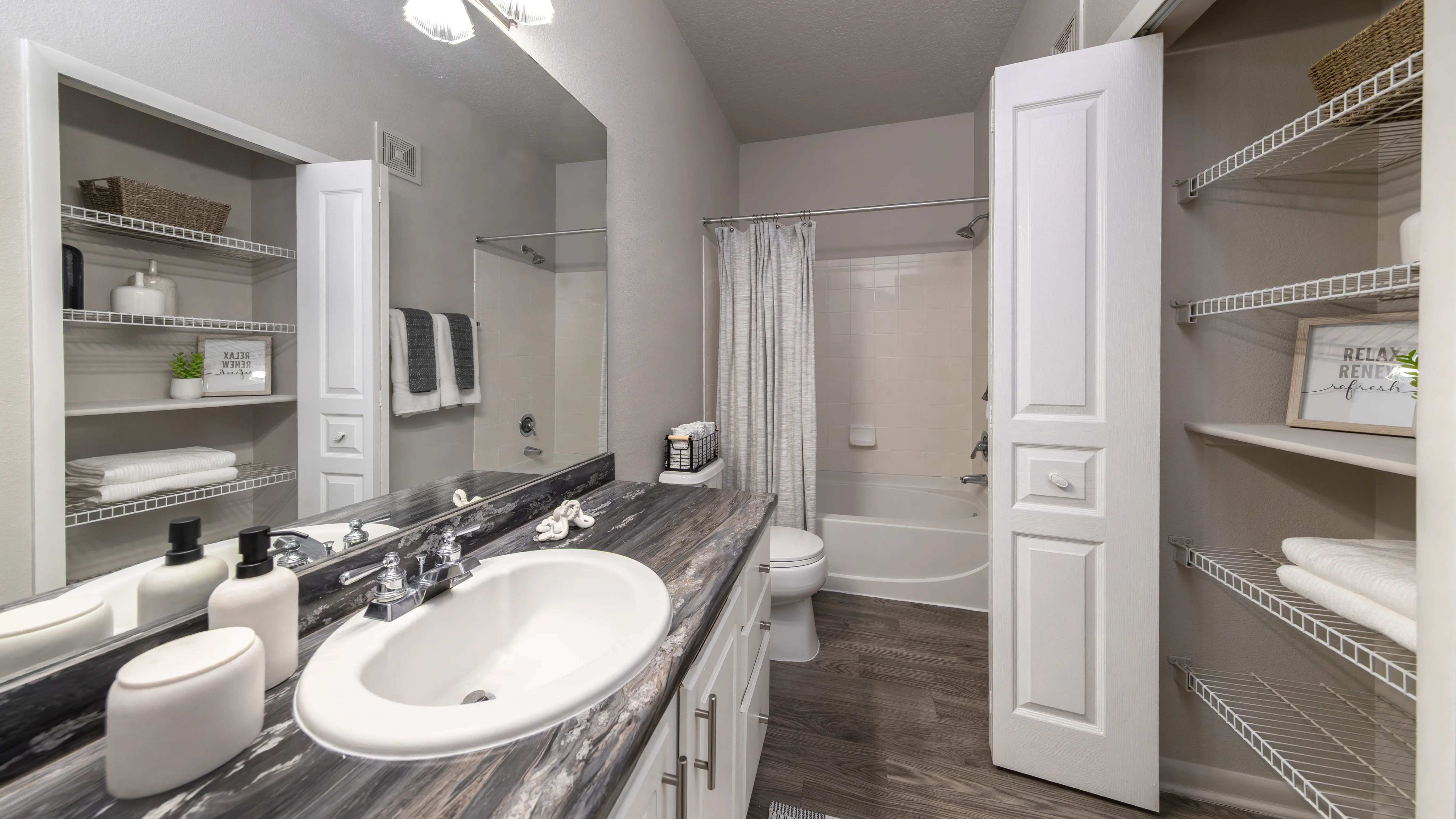 Enjoy sleek design and everyday functionality with a spacious vanity, modern countertop, and dual linen closets in your primary bath.