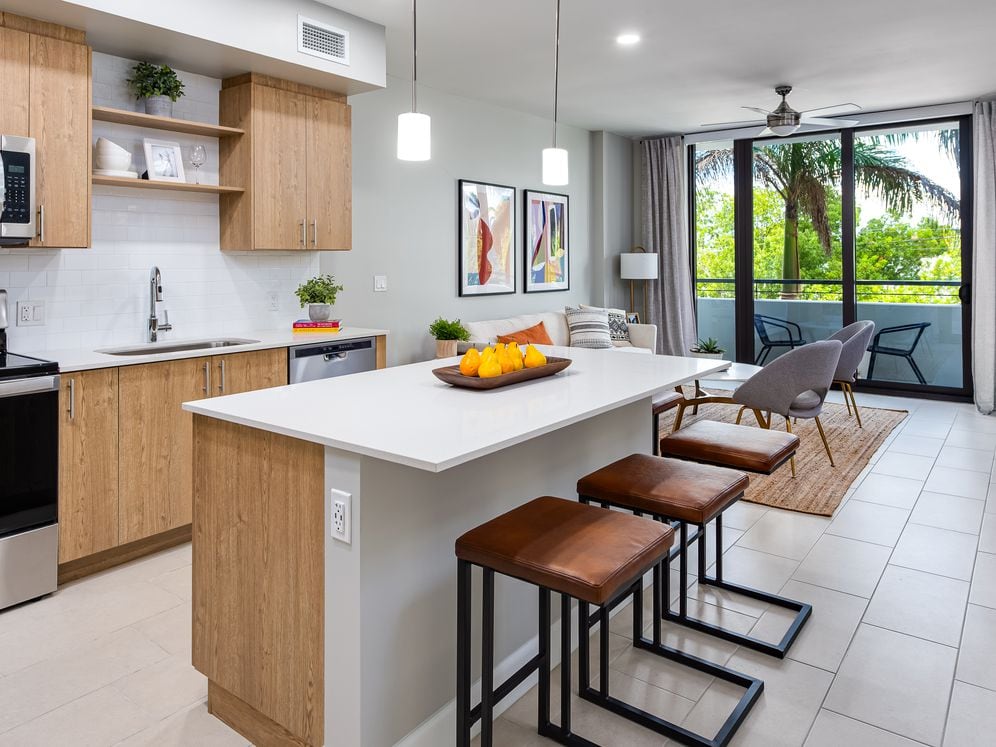 Open concept kitchen with quartz countertop, island, stainless steel appliances and tile backsplash