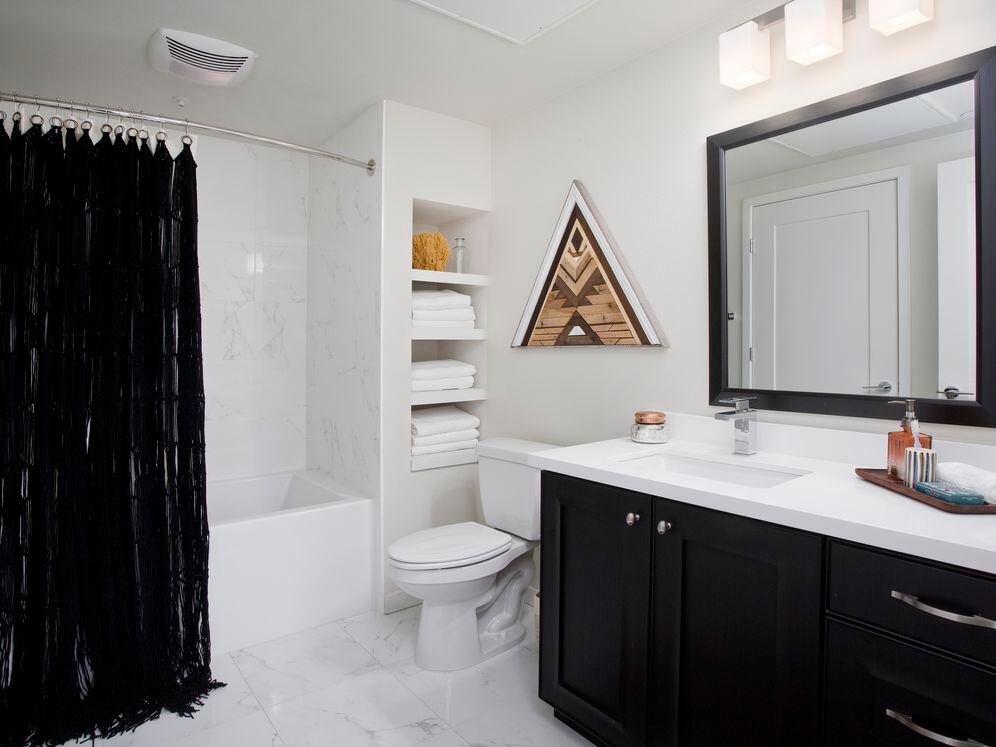 Baths with dark cabinetry, white quartz countertops, and hard surface flooring