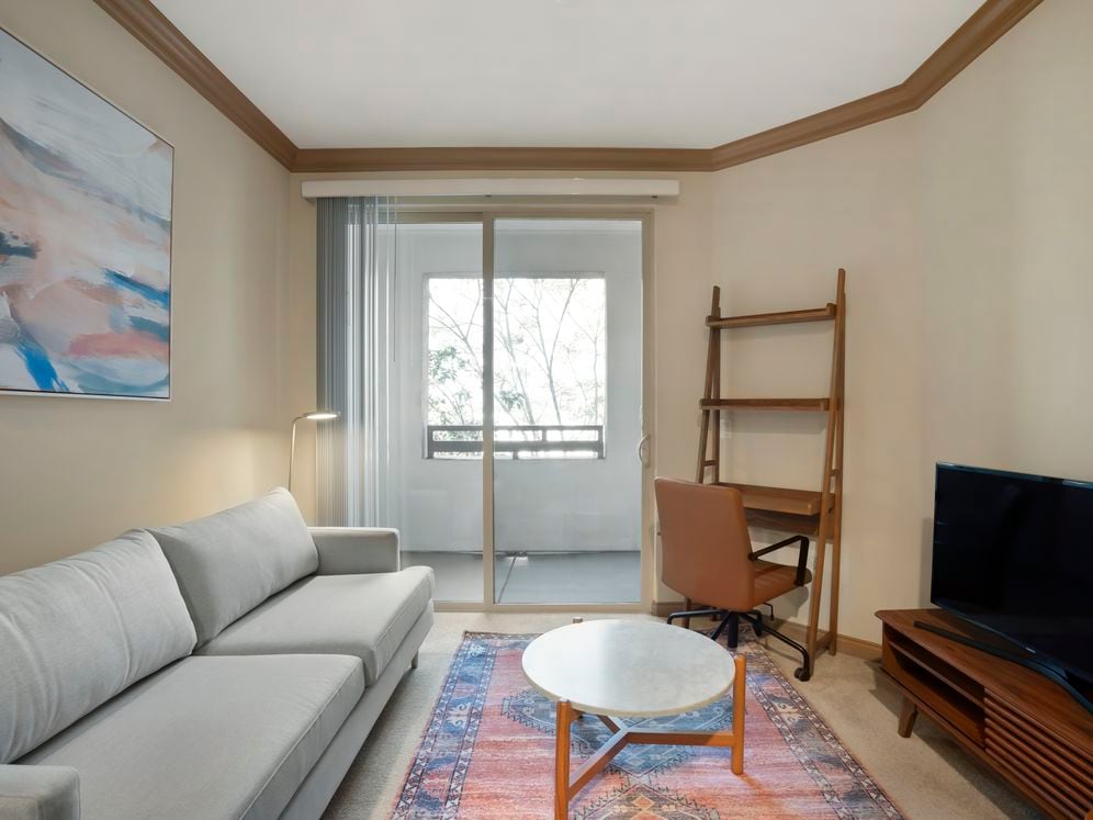 Furnished+ apartment homes come outfitted with a sofa, side chair, side table, coffee table, TV stand and 50" Television (Representative Image – exact items and style of furnishings may vary)