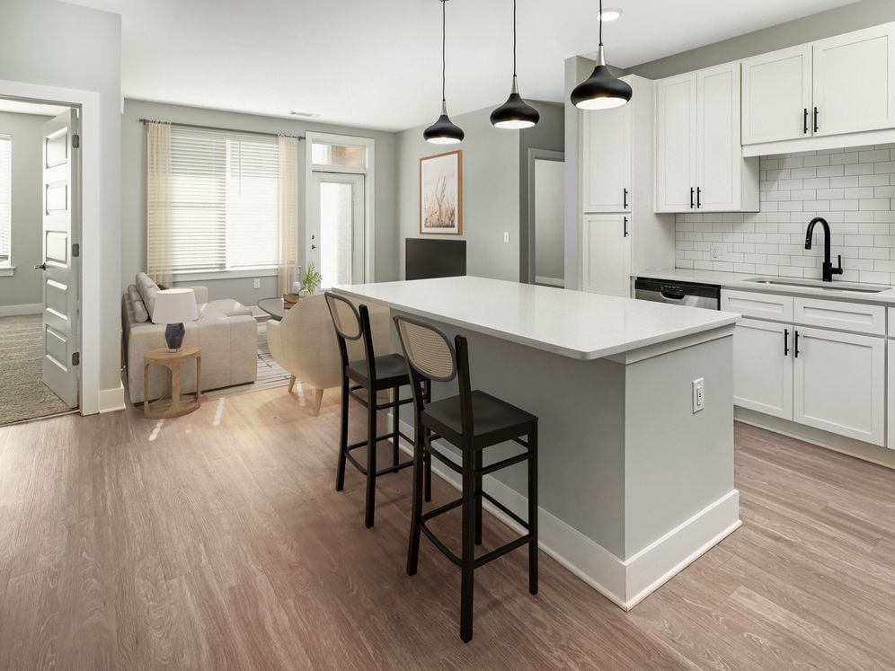 Modern kitchen with white cabinetry, white quartz countertop, stainless steel appliances, and hard surface flooring