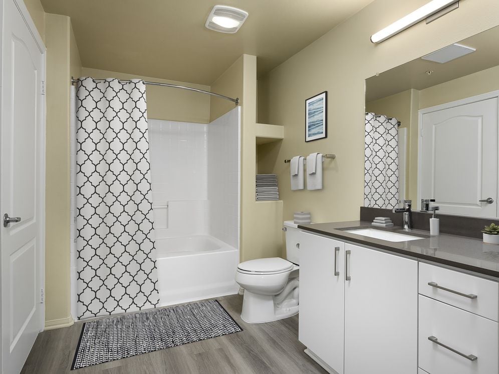 Renovated Package I bath with quartz countertops, white cabinetry, and hard surface vinyl plank flooring