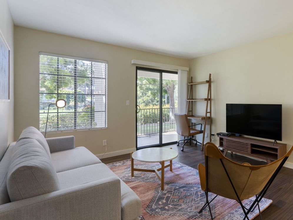 Furnished+ apartment homes come outfitted with a sofa, side chair, side table, coffee table, TV stand and 50" Television (Representative Image – exact items and style of furnishings may vary)