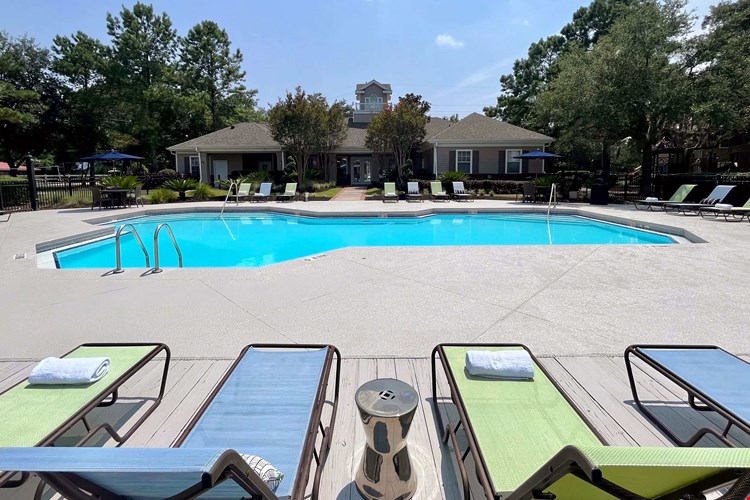 Dive into relaxation at the sparkling resort-style pool at Eagles Pointe Apartments. Surrounded by lush greenery and comfortable lounge chairs, it's the perfect spot to unwind or socialize.