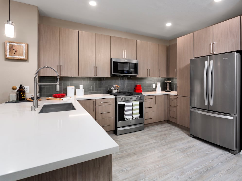 Design Scheme II Kitchen with quartz countertops, stainless steel appliances, and hard surface plank flooring
