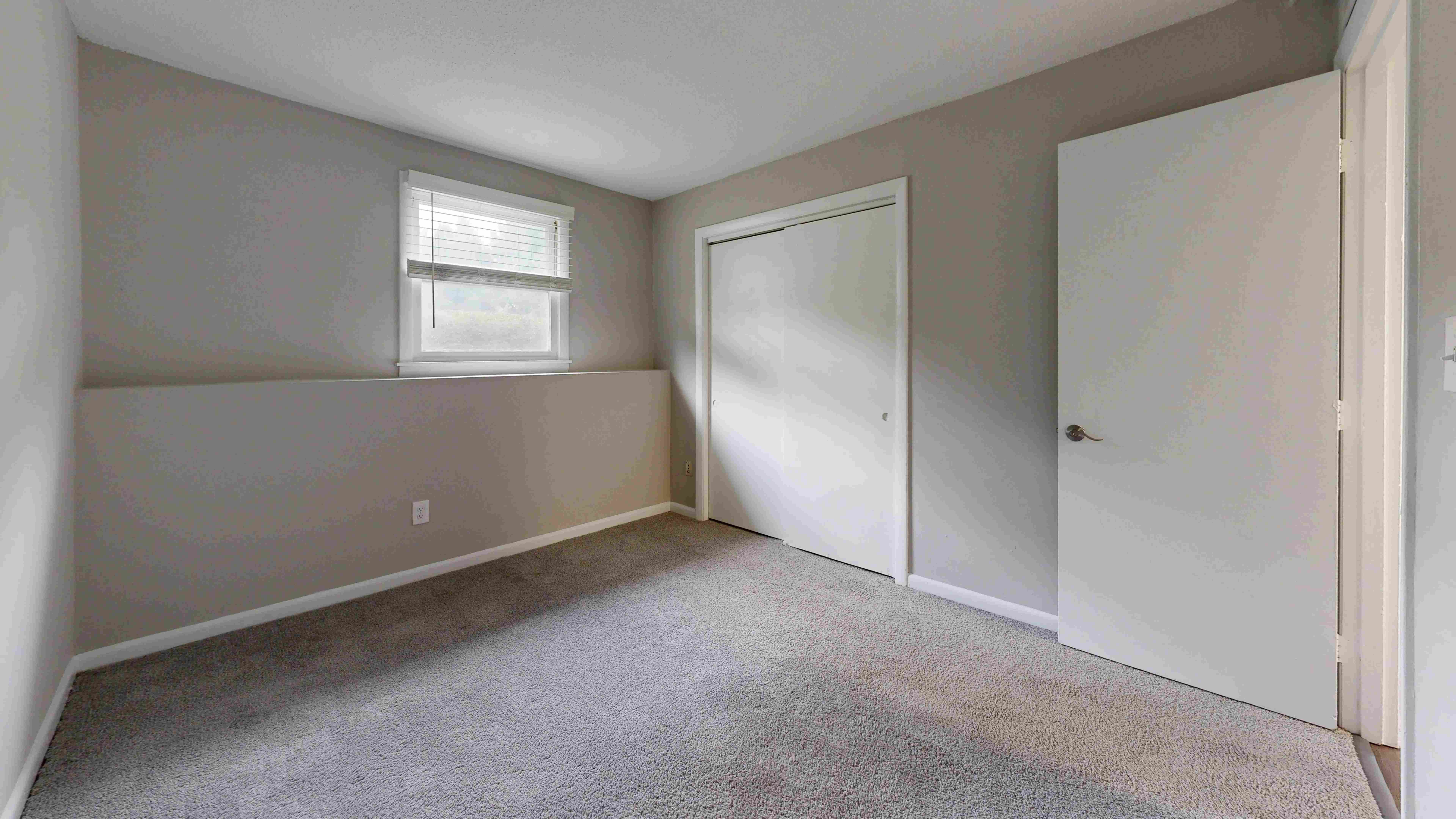 This space features soft carpeting, a large window for natural light, and ample closet space for all your storage needs.