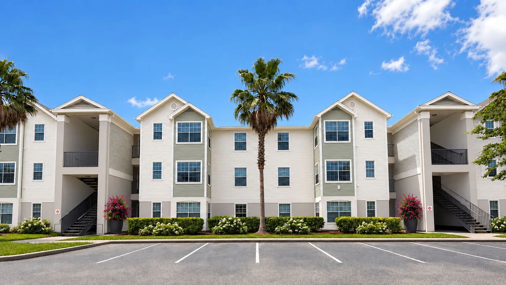 Discover the inviting setting of Indigo Isles, where refreshed building exteriors, palm trees, and vibrant landscaping come together to create a bright and welcoming community atmosphere.